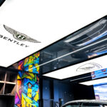 Luxury Bentley car displayed in a premium garage lounge with stretch ceiling and ambient lighting.